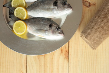raw fish silver tray on wooden background pine
