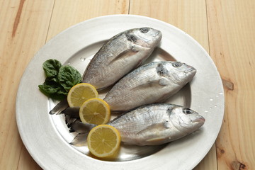 raw fish silver tray on wooden background pine

