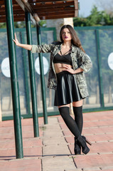 Portrait photo of a lady with bold purple big fleshy lips wear army jacket, long shocks, leather skirt and heels, full body length photo