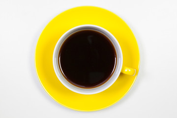 Yellow cup of coffee on a white table