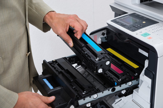 Businessman Fixing Cartridge In Photocopy Machine