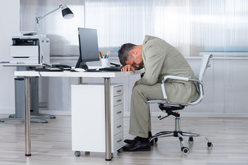 Businessman Sleeping On Desk In Office