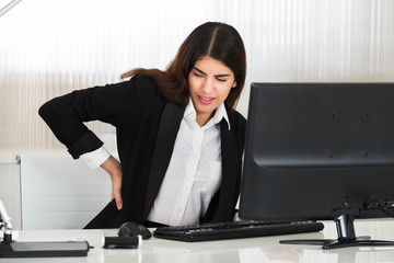 Businesswoman Suffering From Back Pain At Desk