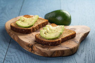 toasted rye bread with sliced avocado and herbs