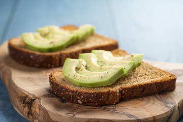 toasted rye bread with sliced avocado and herbs