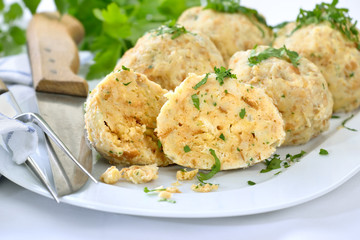 Deftige bayerische Semmelknödel mit Petersilie auf weißer Platte serviert