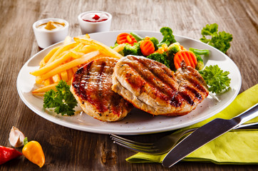 Grilled steaks, French fries and vegetable salad 