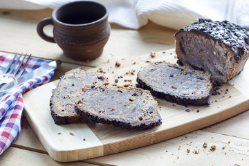 Stollen traditional German Christmas yeast cake with raisins served with a cup of coffee decorated with tablecloth on wooden table