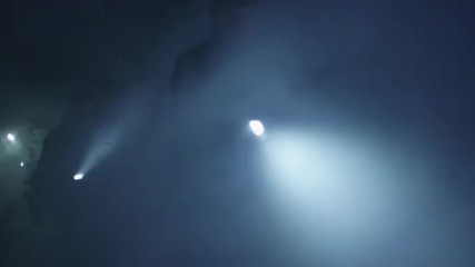 People with flashlights are running around forest in the dark at night. Shot on RED Cinema Camera.
