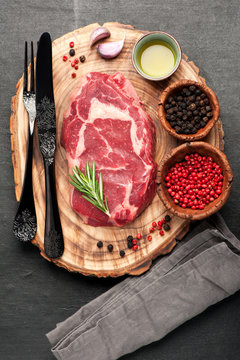 Raw fresh meat Ribeye steak entrecote and seasoning on wooden board