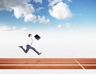 A young businessman running forward with a black folder in hand approaching the finish line. Blue sky at the background. Concept of competition.