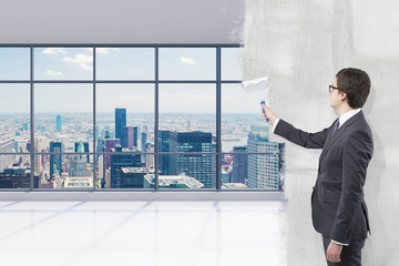Fototapeta premium Businessman covering office view with paint