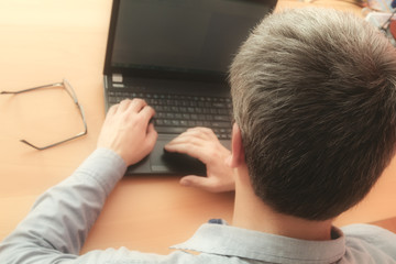 Office work on a laptop. Shallow depth of field on the head.