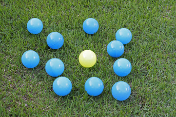 Colorful plastic balls around another - concept of bullying