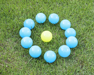 Colorful plastic balls around another - concept of bullying