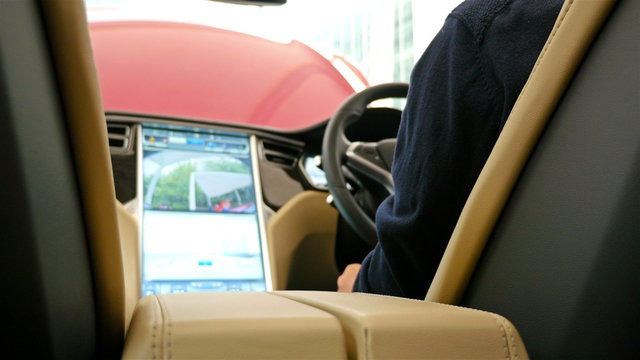 Man sitting in the driver seat of a car and sliding it