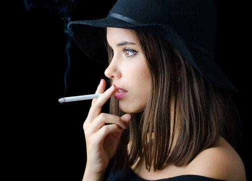 Portrait of the beautiful elegant girl smoking cigarette