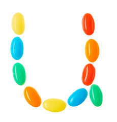 U letter made of multicolored candies isolated on white