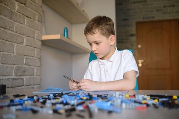 6 years boy playing with technic plastic blocks indoor