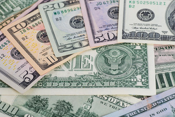 A pile of one hundred US dollar bills on a table