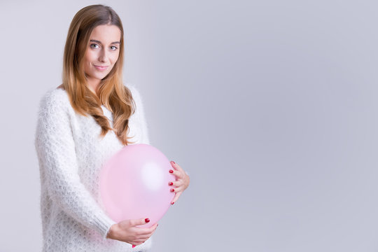 Woman Holding a Balloon to her Belly
