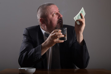 Broke Business man with a glass of whiskey and cigarette