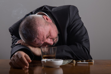 Obraz premium Broke Business man with a glass of whiskey and cigarette