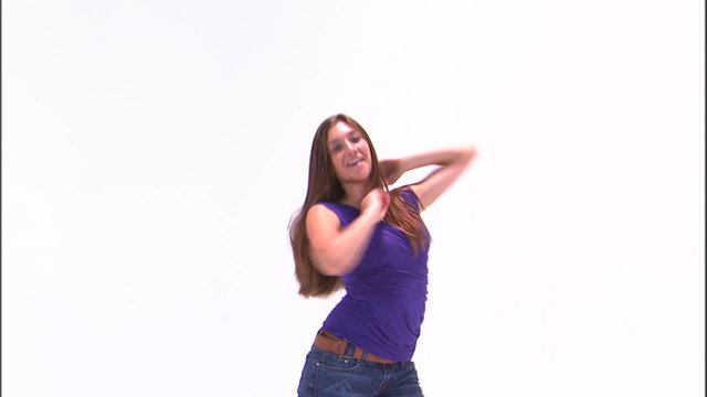Girl in a purple shirt and jeans dancing on a white background.