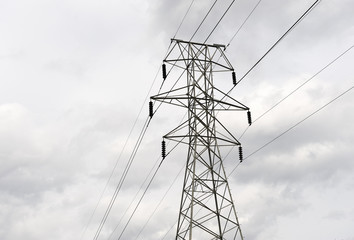 high voltage power tower under cloudy sky