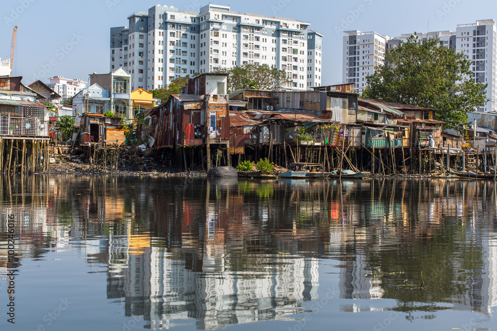 Wall mural Views of the city's Slums from the river (in the background and in reflection of the new buildings) Ho Chi Minh City (Saigon), Vietnam.