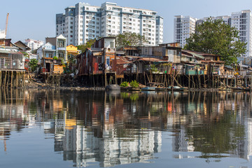 Fototapeta na wymiar Views of the city's Slums from the river (in the background and in reflection of the new buildings) Ho Chi Minh City (Saigon), Vietnam.