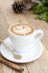 Cup of Latte art coffee with cinnamon on wooden table