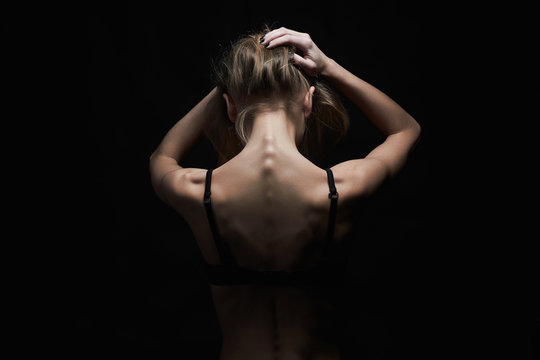 young woman with naked back over black background.sport body girl