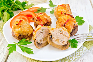 Champignons stuffed meat cut in white plate on light board