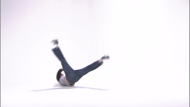 Break dancer doing a windmill on a white background.