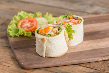 Sandwich fried egg with ham roll on wood board.