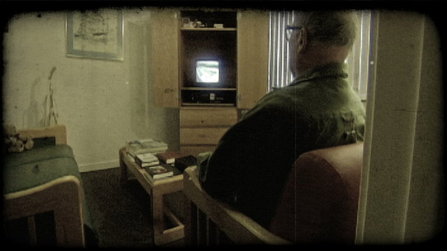 Elderly man watches tv. Vintage stylized video clip.