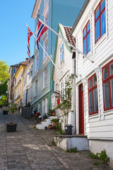 Fototapeta na wymiar Street with old wooden houses and Norwegian flags in Bergen