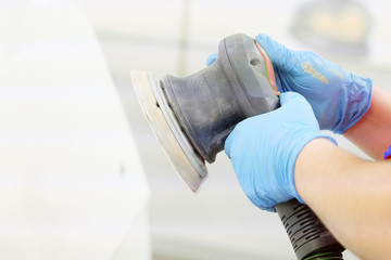Painter polishes a car body component