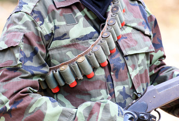 A man in soldier suit with rifle and bullets on blur background 
