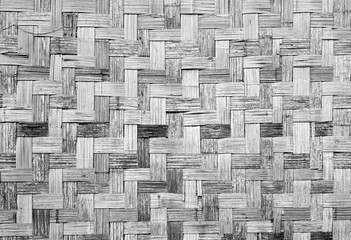 Wall of plaited bamboo strips vernecular outdoor grey scale