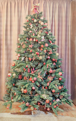 Green Christmas tree with many vibrant colored ornaments, colored lights, decorated, close up, indoor, Christmas spirit.