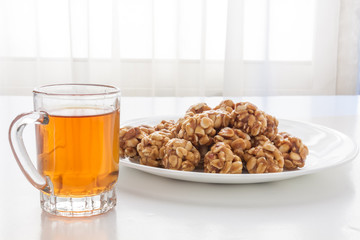 Sweet peanut balls in a plate and glass of black tea