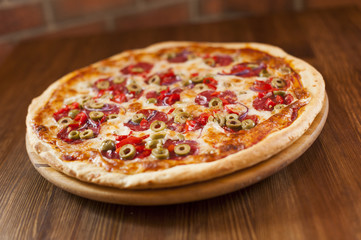 Tasty pizza italiana on the wooden table