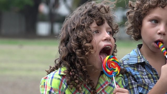 Brothers Eating Lollipop Candy