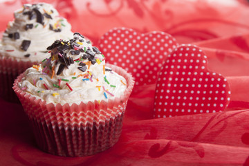 Cupcakes   and the heart symbol on a red background.