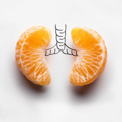 Shadows of illness / A health concept of unhealthy human lungs of a smoker with lung cancer in dark shadows, made of mandarin segments.