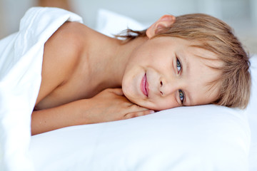 Fototapeta na wymiar happy little boy in morning bed 