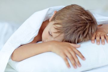 Obraz na płótnie Canvas happy little boy in morning bed 