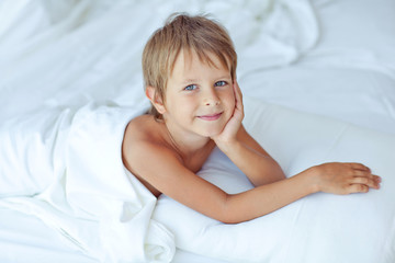 happy little boy in morning bed 